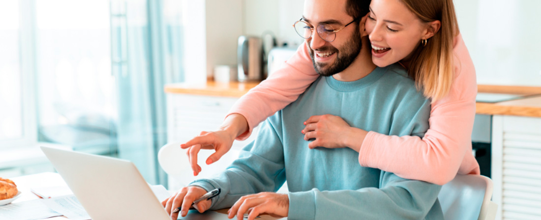 Pareja consultando el ordenador en su casa