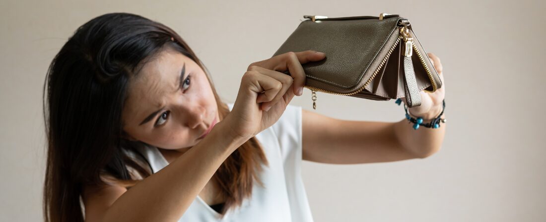 Mujer dando la vuelta a una cartera sin dinero