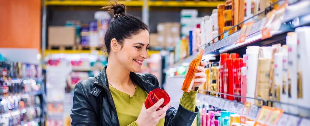 Mujer en un supermercado comparando el precio de dos productos