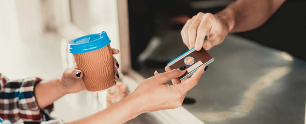 persona pagando un café con una tarjeta de crédito